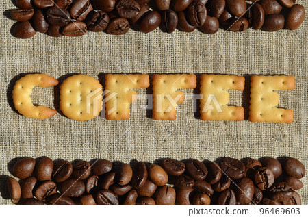 Coffee. The word from the edible letters lies on the gray canvas with coffee beans Coffee. The word from the edible letters lies on the gray canvas with coffee beans 96469603