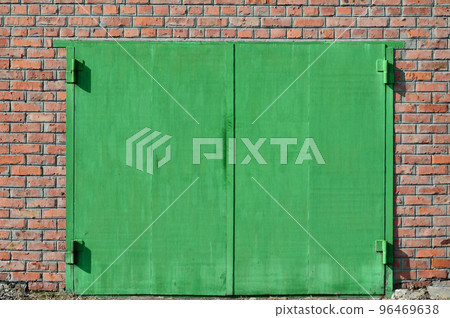 The texture of a painted metal gate from a brick garage 96469638