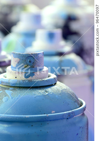 A lot of dirty and used aerosol cans of bright blue paint. Macro photograph with shallow depth of field. Selective focus on the spray nozzle A lot of dirty and used aerosol cans of bright blue paint. Macro photograph with shallow depth of field. Selective focus on the spray nozzle 96470097