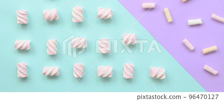Colorful marshmallow laid out on violet and blue paper background. pastel creative textured pattern. minimal Colorful marshmallow laid out on violet and blue paper background. pastel creative textured pattern. minimal 96470127