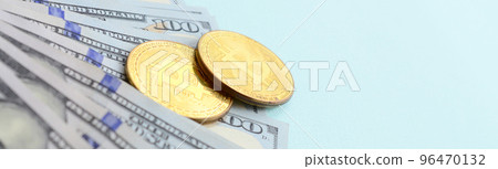 Golden bitcoins and hundred dollar bills lies on light blue background 96470132