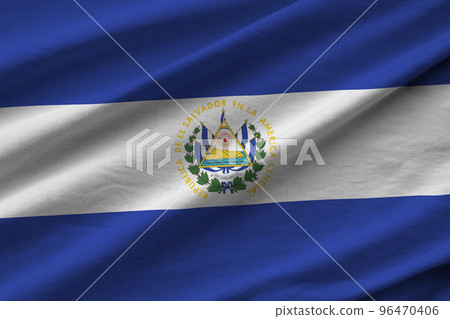 El Salvador flag with big folds waving close up under the studio light indoors. The official symbols and colors in banner El Salvador flag with big folds waving close up under the studio light indoors. The official symbols and colors in banner 96470406
