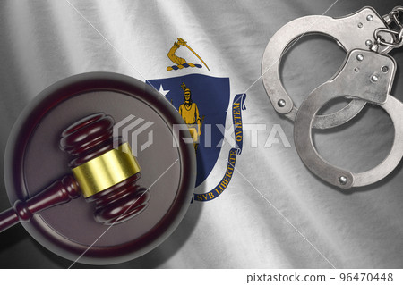 Massachusetts US state flag with judge mallet and handcuffs in dark room. Concept of criminal and punishment Massachusetts US state flag with judge mallet and handcuffs in dark room. Concept of criminal and punishment 96470448