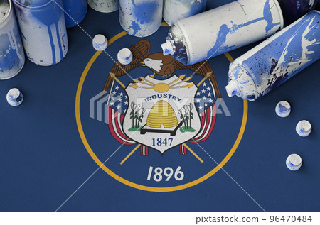 Utah US state flag and few used aerosol spray cans for graffiti painting. Street art culture concept 96470484