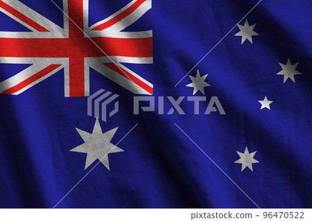 Australia flag with big folds waving close up under the studio light indoors. The official symbols and colors in banner 96470522