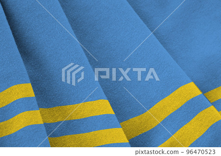 Aruba flag with big folds waving close up under the studio light indoors. The official symbols and colors in banner 96470523