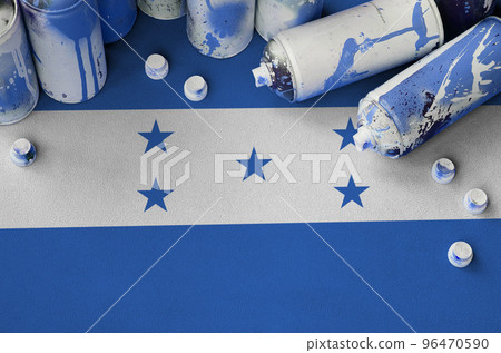 Honduras flag and few used aerosol spray cans for graffiti painting. Street art culture concept 96470590