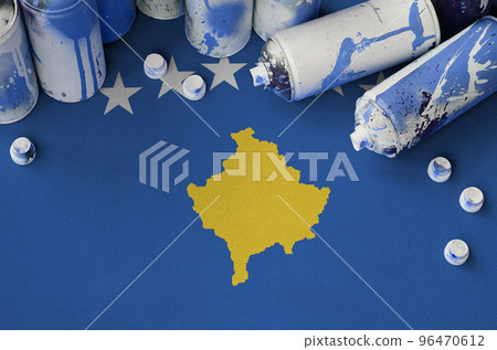 Kosovo flag and few used aerosol spray cans for graffiti painting. Street art culture concept 96470612
