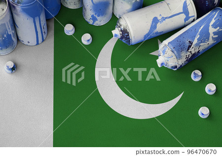 Pakistan flag and few used aerosol spray cans for graffiti painting. Street art culture concept Pakistan flag and few used aerosol spray cans for graffiti painting. Street art culture concept 96470670