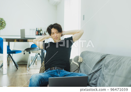 A man looking at a computer in the living room　 96471039