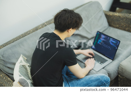 A man looking at a computer in the living room　 96471044