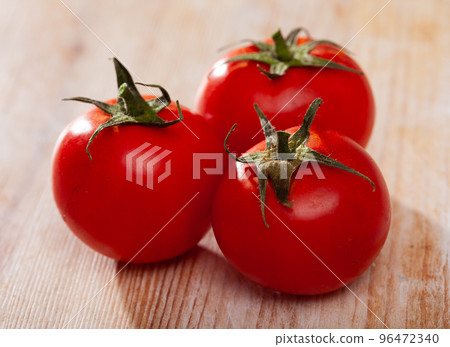 Ripe tomatoes on wooden surface Ripe tomatoes on wooden surface 96472340
