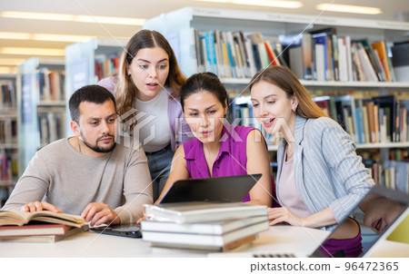 Group of students in the library is preparing for classes on a laptop Group of students in the library is preparing for classes on a laptop 96472365