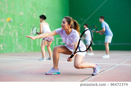 Woman playing frontenis with partners at sunny day, healthy lifestyle concept 96472374