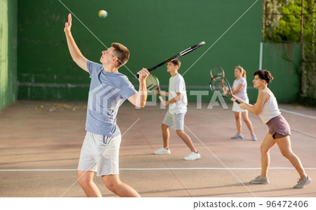 Man playing frontenis with partners at sunny day, healthy lifestyle concept 96472406