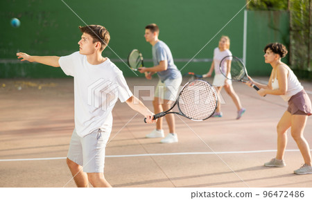 Male sportsman preparing to hit ball with racket. Frontenis game on outdoor court 96472486