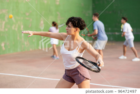 Woman playing frontenis with partners at sunny day, healthy lifestyle concept 96472497