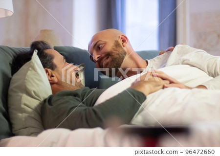 Homosexual men looking at each other while lying in bed Homosexual men looking at each other while lying in bed 96472660