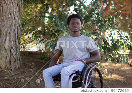 Young Black man with disability spending time in city park. 96472683