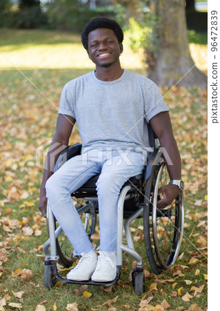 Handsome Black guy in wheelchair spending time outdoors 96472839