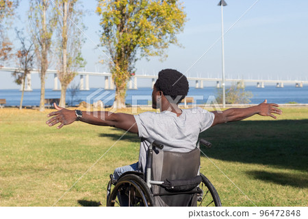 Young Black man in wheelchair enjoying beautiful sea view. Young Black man in wheelchair enjoying beautiful sea view. 96472848