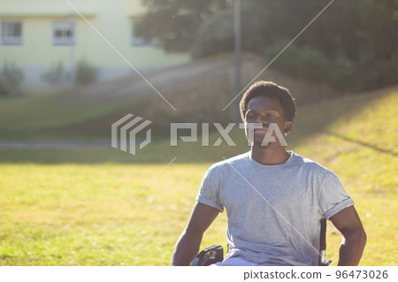 Portrait of happy Black man in wheelchair enjoying sunny weather 96473026
