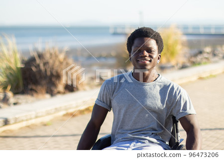 Happy Black man in wheelchair enjoying warm summer day Happy Black man in wheelchair enjoying warm summer day 96473206