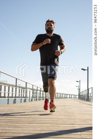 Portrait of serious man with disability running on bridge 96473253