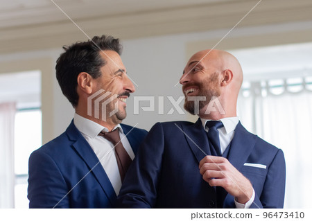 Homosexual couple in official suits smiling each other 96473410
