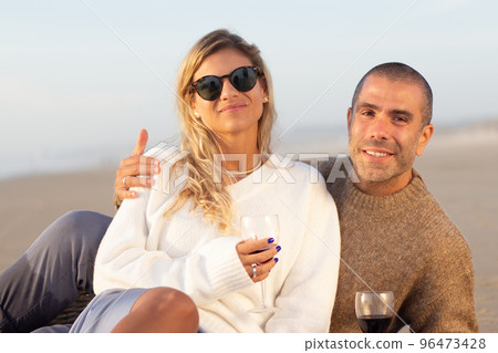 Portrait of couple at picnic at sunset Portrait of couple at picnic at sunset 96473428