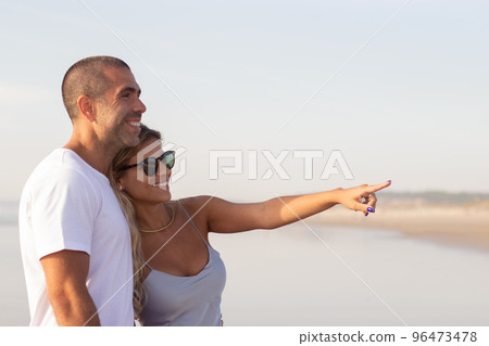 Content male and female couple spending time at beach Content male and female couple spending time at beach 96473478