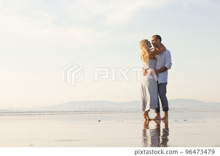 Delighted male and female couple spending time at beach Delighted male and female couple spending time at beach 96473479