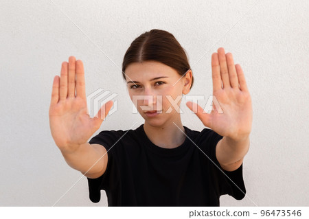 Portrait of confident young woman making stop gesture Portrait of confident young woman making stop gesture 96473546