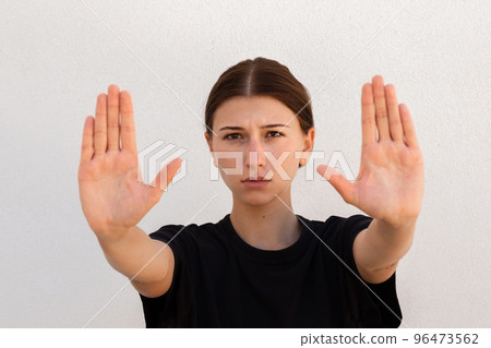 Portrait of serious young woman making refusal gesture Portrait of serious young woman making refusal gesture 96473562