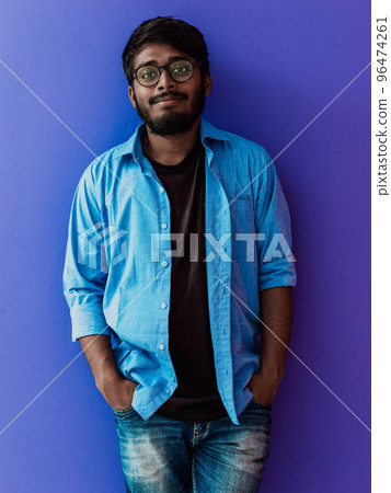Indian student with blue backpack, glasses and notebook posing on green background. The concept of education and schooling. Time to go back to school Indian student with blue backpack, glasses and notebook posing on green background. The concept of education and schooling. Time to go back to school 96474261