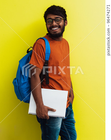 Indian student with blue backpack, glasses and notebook posing on green background. The concept of education and schooling. Time to go back to school 96474271