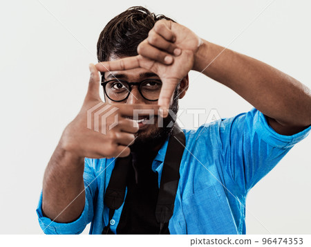 Young handsome man focusing with fingers, framing with hands isolated on grey background. Close up portrait 96474353