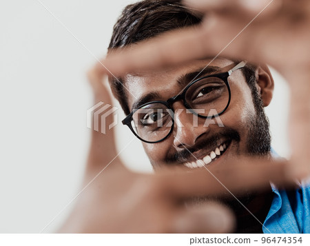 Young handsome man focusing with fingers, framing with hands isolated on grey background. Close up portrait 96474354