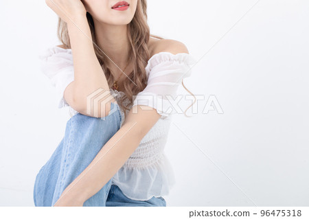 A woman who smiles while resting her chin A woman who smiles while resting her chin 96475318
