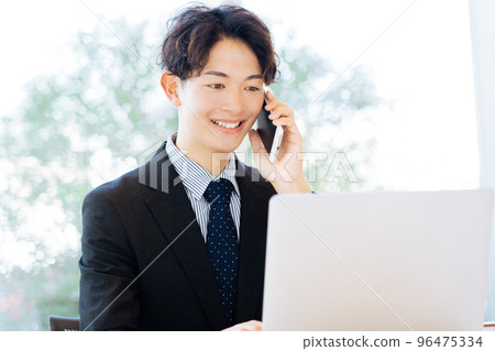 A man who calls while watching a computer 96475334