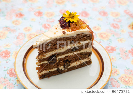 Close-up of a delicious carrot cake decorated with an edible flowers on a plate. 96475721