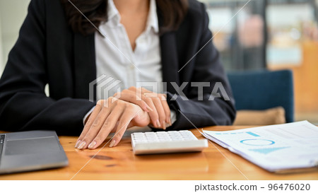 Professional Asian female accountant or financial analyst sits at her office desk. cropped 96476020