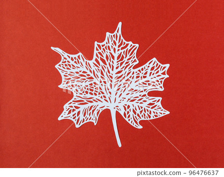A carve of white paper maple leaves on a red background. 96476637