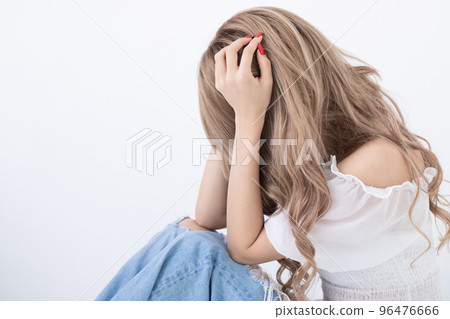 擔心的女人坐下來抱著她的膝蓋 96476666