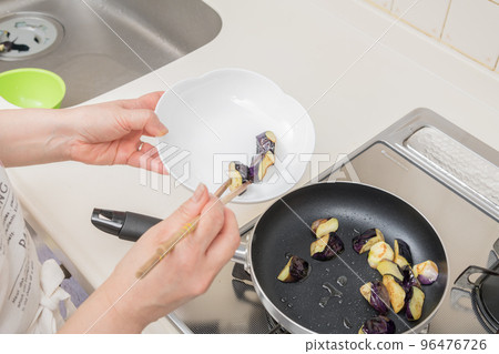 [Make the eggplant deep-fried in soy sauce. Put the fried eggplant on a plate] 96476726