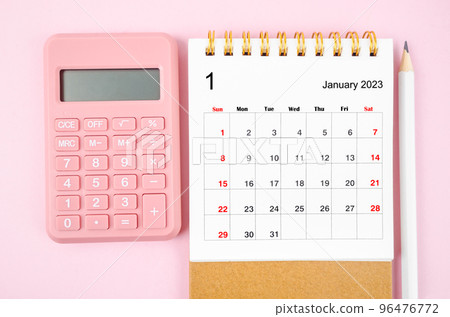 The January 2023 desk calendar for 2023 year with calculator on pink color background. The January 2023 desk calendar for 2023 year with calculator on pink color background. 96476772