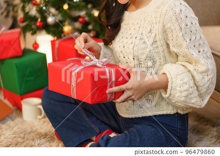 Christmas celebration concept, Young asian woman sitting on the floor and opening christmas gift 96479860