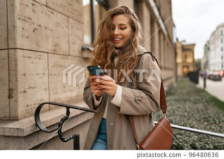 Young woman using mobile device standing in the city 96480636