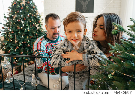 Happy family near fir-tree in bedroom, Christmas celebration at home Happy family near fir-tree in bedroom, Christmas celebration at home 96480697