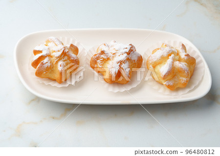 Homemade profiteroles with powdered sugar on white plate 96480812